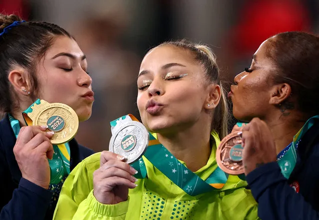 Gold medallist Kayla DiCello of the U.S. celebrates on the podium after winning the women's all-around final alongside silver medallist Brazil's Flavia Saraiva and bronze medallist Jordan Chiles of the U.S. at the Pan Am Games in Santiago, Chile on October 23, 2023. (Photo by Agustin Marcarian/Reuters)