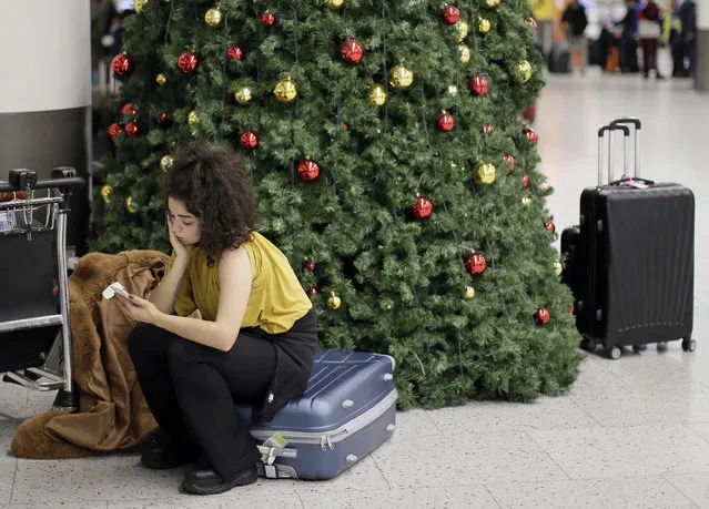 A woman waits in the departures area at Gatwick airport, near London, as the airport remains closed with incoming flights delayed or diverted to other airports, after drones were spotted over the airfield last night and this morning, Thursday, December 20, 2018. London's Gatwick Airport remained shut during the busy holiday period Thursday while police and airport officials investigate reports that drones were flying in the area of the airfield. (Photo by Tim Ireland/AP Photo)