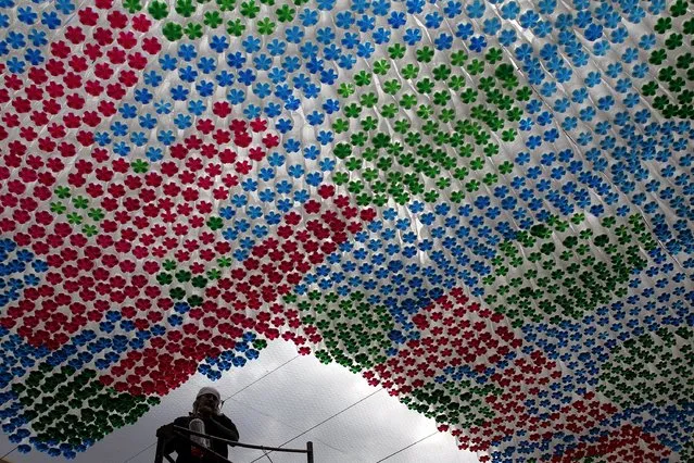 A worker stands next to an installation made of plastic bottles in Tegucigalpa March 31, 2015. The Museum of National Identity is working on installations made from recycled plastic bottles as a way to encourage recycling in the community, local media reported. (Photo by Jorge Cabrera/Reuters)