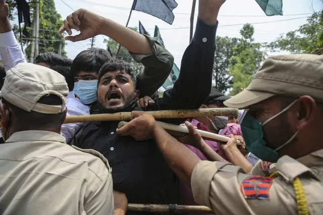 Activists of Peoples Democratic Party scuffle with police during a protest marking the second anniversary of Indian government scrapping Kashmir’s semi- autonomy in Jammu, India, Thursday, August 5, 2021. On Aug. 5, 2019, Indian government passed legislation in Parliament that stripped Jammu and Kashmir’s statehood, scrapped its separate constitution and removed inherited protections on land and jobs. (Photo by Channi Anand/AP Photo)