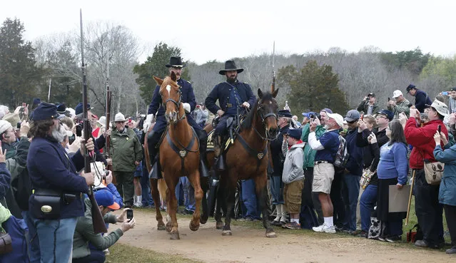 A re-enactor portraying Union General Ulysses S. Grant, right, and a fellow officer arrive at the McLean house to meet with Confederate General Robert E. Lee during the commemoration of the 150th anniversary of the surrender of the Army of Northern Virginia at Appomattox Court House, Thursday, April 9, 2015, in Appomattox, Va. (Photo by Steve Helber/AP Photo)