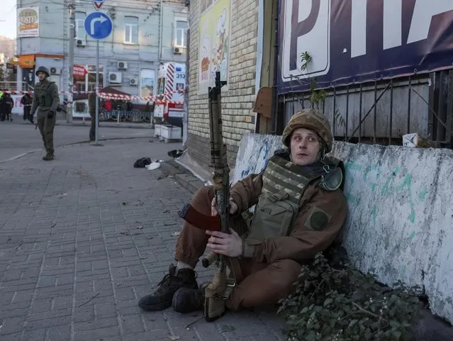 A Ukrainian serviceman sits in a street after a Russian drone strike, which local authorities consider to be Iranian-made unmanned aerial vehicles (UAVs) Shahed-136, amid Russia's attack on Ukraine, in Kyiv, Ukraine on October 17, 2022. (Photo by Gleb Garanich/Reuters)