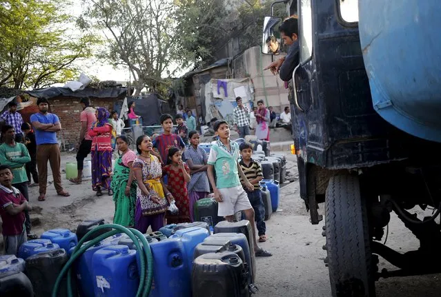 Residents with their empty containers wait to fill water from a municipal tanker in New Delhi, India, February 21, 2016. (Photo by Anindito Mukherjee/Reuters)