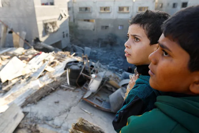 Palestinian children look at the damage at the site of Israeli strikes on houses, amid the ongoing conflict between Israel and the Palestinian Islamist group Hamas, in Khan Younis in the southern Gaza Strip on December 10, 2023. (Photo by Ibraheem Abu Mustafa/Reuters)