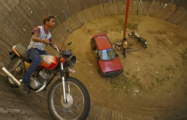 A stuntman rides a motorcycle inside the “Well of Death” attraction during a fair in Bhaktapur April 20, 2015. (Photo by Navesh Chitrakar/Reuters)
