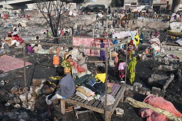 Residents collect their belongings from the debris of their houses after fire broke out shanties in a slum area of Teen Hatti in Karachi, Pakistan on January 05, 2024. (Photo by Sabir Mazhar/Anadolu via Getty Images)