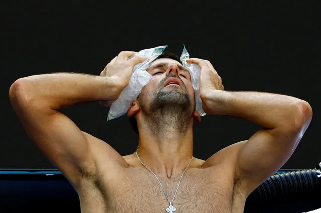 Serbia's Novak Djokovic holds ice packs on his head during his quarter final match against Taylor Fritz of the U.S. at the Australian Open on January 23, 2024. (Photo by Issei Kato/Reuters)