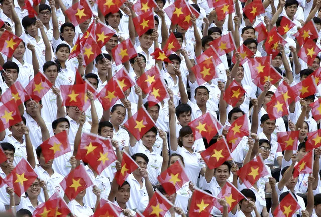 Performers wave Vietnamese national flags during a parade celebrating the 40th anniversary of the end of the Vietnam War which is also remembered as the “Fall of Saigon”, in Ho Chi Minh City, Vietnam, Thursday, April 30, 2015. (Photo by Dita Alangkara/AP Photo)