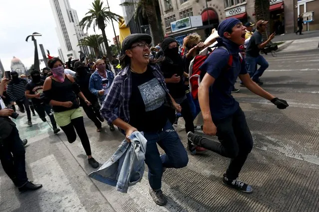Protesters run during a march for Labor Day in Mexico City May 1, 2015. (Photo by Edgard Garrido/Reuters)