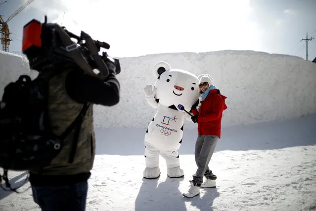 A reporter poses with the mascot for the 2018 PyeongChang Winter Olympics Soohorang during the Pyeongchang Winter Festival, near the venue for the opening and closing ceremony of the PyeongChang 2018 Winter Olympic Games in Pyeongchang, South Korea, February 10, 2017. (Photo by Kim Hong-Ji/Reuters)
