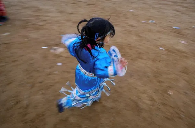 An Innu First Nations girl in traditional costume takes part in a ceremony at a camp set up for the annual Innu clan gathering on the eve of Canada's first National Day for Truth and Reconciliation, honouring the lost children and survivors of Indigenous residential schools, their families and communities, at Gull Island, Labrador, Canada on September 29, 2021. (Photo by Greg Locke/Reuters)
