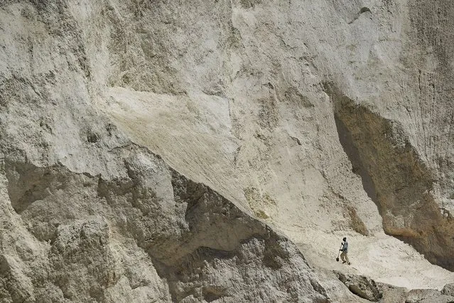 A man digs for gravel and sand at the gravel pit of Laboule, one of principal source of sand for construction sites in Haiti, Saturday, November 6, 2021. (Photo by Matias Delacroix/AP Photo)