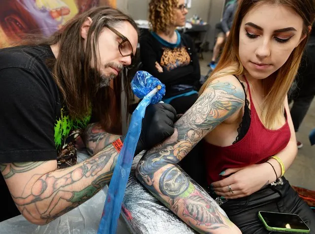 One of the invited artists, Tom Storm, works on the arm of Kerrie Hibbert at the 2017 Tattoo Collective event at the Old Truman Brewery in London, England on February 17, 2017. (Photo by PA Wire)