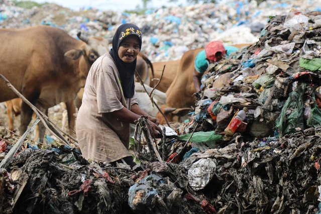A woman searches for recyclable waste at the Akhir Alue Liem landfill in Lhokseumawe, Aceh on November 4, 2021. (Photo by Azwar Ipank/AFP Photo)