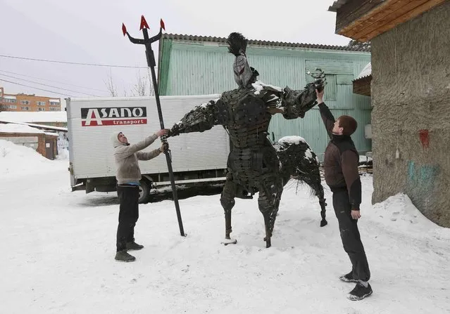 Mechanic and welder Sergei Kulagin (L) and his assistant prepare to transport the “Centaurus” sculpture, made of used car components, outside an automobile repair workshop in the Siberian town of Divnogorsk, Russia, February 20, 2017. (Photo by Ilya Naymushin/Reuters)