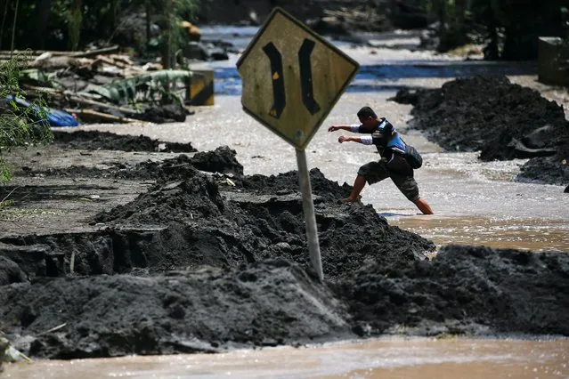 A local walks through water flowing in an area affected by the eruption of Mount Semeru volcano, in Kamar Kajang, Candipuro district, Lumajang, East Java province, Indonesia, December 9, 2021. (Photo by Willy Kurniawan/Reuters)