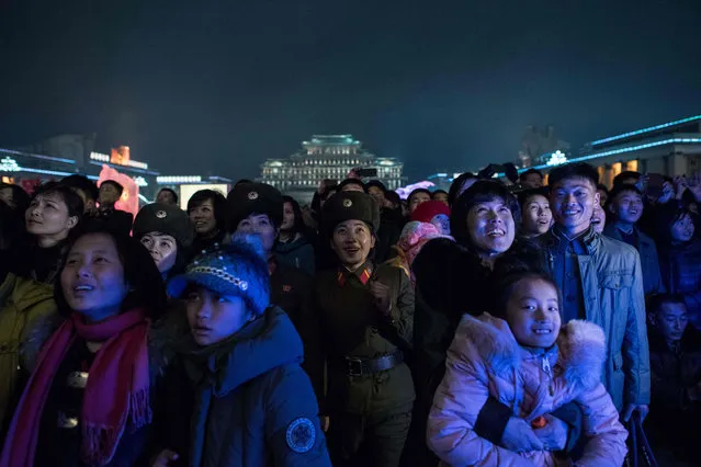 People watch a fireworks display as they visit an ice festival near the Taedong river, on the occasion of the 75th anniversary of the birth of Kim Jong-Il, in central Pyongyang on February 16, 2017. (Photo by Ed Jones/AFP Photo)