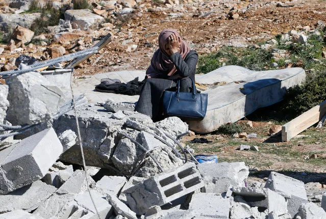 A Palestinian woman reacts as she sits next to the rubble of her house after it was demolished by the Israeli army as it did not have an Israeli-issued construction permit, in the West Bank city of Hebron March 6, 2017. (Photo by Mussa Qawasma/Reuters)