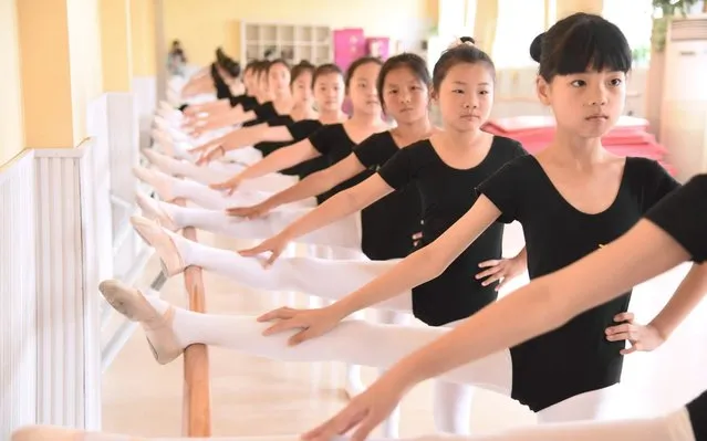Girls practice ballet moves in a dance school in Donghai county in east China's Jiangsu province on July 9, 2019. (Photo by Feature China/Barcroft Media)