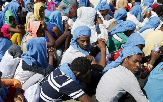 Migrants rest after disembarking from the expedition vessel Phoenix in the Sicilian harbour of Augusta, Italy June 17, 2015. REUTERS/Antonio Parrinello
