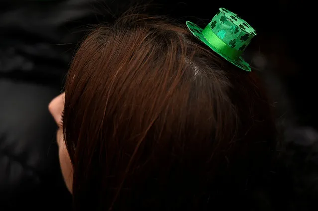 A woman watches the St. Patrick's day parade in Dublin, Ireland on March 17, 2017. (Photo by Clodagh Kilcoyne/Reuters)