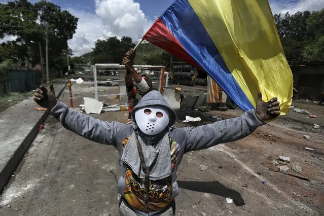 Protesters shout slogans during an anti-government protest in Yumbo, near Cali, Colombia, Tuesday, May 18, 2021. Colombians have taken to the streets for weeks across the country after the government proposed tax increases on public services, fuel, wages and pensions, but have continued even after President Ivan Duque walked back the tax hike. (Photo by Andres Gonzalez/AP Photo)