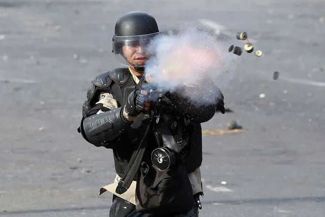 A member of the National Police fires tear gas towards anti-government protesters during a demonstration in Caracas, Venezuela, on April 21, 2014. (Photo by Christian Veron/Reuters)