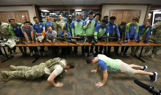 Seattle Sounders midfielder Aaron Kovar, right, takes part in a push-up contest with Staff Sgt. Keith Wade, left, an engineer in the U.S. Army 1st Special Forces Group, during a visit by the MLS soccer team to Joint Base Lewis-McChord, Monday, May 9, 2016, in Washington state. The two were fairly equally matched, but Wade was wearing more than 50 lbs. of military gear during the contest, so he was credited by Kovar as the winner. (Photo by Ted S. Warren/AP Photo)