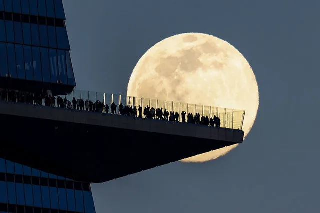 Full moon also known as “Snow Moon” rises behind people standing on The Edge, the outdoor observation deck in Manhattan, New York City, United States on February 15, 2022. (Photo by Tayfun Coskun/Anadolu Agency via Getty Images)