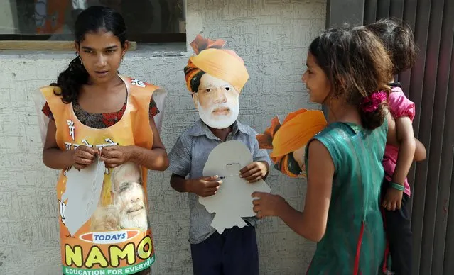 A child wears a mask of Bharatiya Janata Party's prime ministerial candidate Narendra Modi at the BJP’s state headquarters in Gandhinagar, on May 16, 2014. (Photo by Divyakant Solanki/EPA)