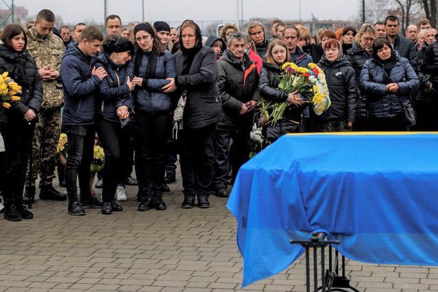 Relatives and friends mourn next to the coffin of Private Volodymyr Dukh, 29, who was killed in battle amid Russia’s attack on Ukraine, at the Lychakiv cemetery, in Lviv, April 1, 2022. (Photo by Alkis Konstantinidis/Reuters)