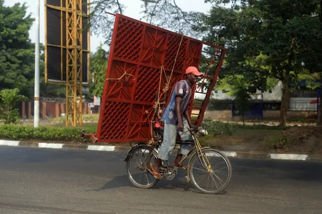 A cyclist carries a metal gate on the back of his bicycle in Bujumbura, Burundi, Sunday July 19, 2015. As Burundians are getting ready to go to the poll Tuesday July 21, three candidates, including two former presidents, announced their withdrawal from Burundi's upcoming presidential race, predicting the contest in this restive African nation will not be free and fair. (Photo by Jerome Delay/AP Photo)