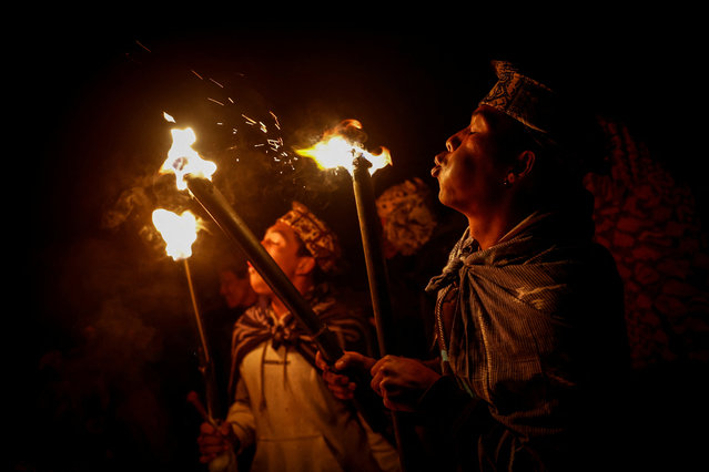 Tenggerese Hindu worshippers blow their torches before walking up Mount Bromo during the Yadnya Kasada festival in Probolinggo, East Java, Indonesia, on June 22, 2024. (Photo by Willy Kurniawan/Reuters)