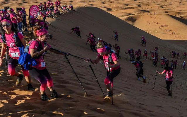 Women clumb up a sand dune as they take part in the desert trek “Rose Trip Maroc”, on November 4, 2019 in the erg Chebbi near Merzouga. The Rose Trip Maroc is a female-oriented trek where teams of three must travel through the southern Moroccan Sahara desert with a compass, a map and a topographical reporter. (Photo by Jean-Philippe Ksiazek/AFP Photo)