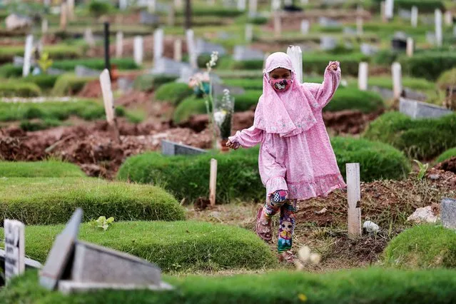 A Muslim girl walks while visiting her relative's grave, who passed away last year due to coronavirus disease (COVID-19), at the Rorotan cemetery complex in Jakarta, Indonesia, April 1, 2022. (Photo by Willy Kurniawan/Reuters)