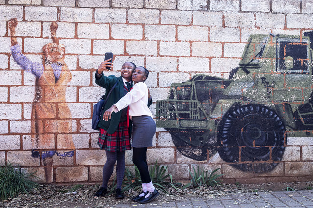 Girls pose for pictures at a mural after visiting the Hector Pieterson Museum on June 16, 2024 in Soweto, South Africa. The Soweto Uprising began on June 16, 1976, as a peaceful student protest against the enforcement of Afrikaans in schools. The police and army's response with tear gas and bullets led to violent clashes, resulting in the deaths of 400 to 700 people, many of them children. The event galvanized international opposition to apartheid and is commemorated annually in South Africa as Youth Day. (Photo by Per-Anders Pettersson/Getty Images)