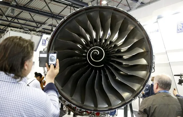 Visitors look at a Rolls-Royce Trent XWB aircraft engine at the company's booth during the ILA Berlin Air Show in Schoenefeld, south of Berlin, Germany, June 1, 2016. (Photo by Fabrizio Bensch/Reuters)