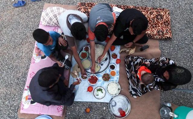 A family breaks fast on the first day of the Muslim holy month of Ramadan, at al-Khazir camp for the internally displaced, located between Arbil and Mosul, on May 27, 2017. (Photo by Karim Sahib/AFP Photo)