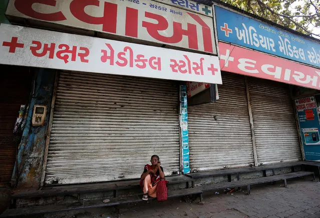 A woman sits outside a closed chemist shop during the nation wide strike by the chemists against what they say is the government's plan to regulate the sale of drugs through an e-platform, in Ahmedabad, India, May 30, 2017. (Photo by Amit Dave/Reuters)