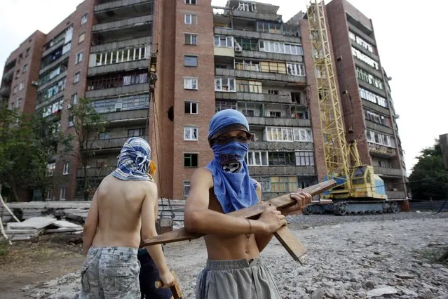 Boys play a game of war between Ukrainian army and pro-Russian separatists in eastern Ukrainian town of Kramatorsk August 7, 2014. (Photo by Valentyn Ogirenko/Reuters)