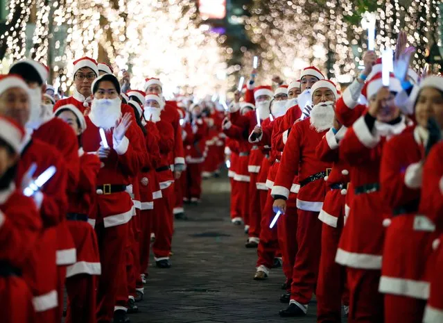 Workers dressed as Santa Clauses parade around Marunouchi business district to encourage the area promotion, in Tokyo, Japan on December 23, 2019. (Photo by Issei Kato/Reuters)