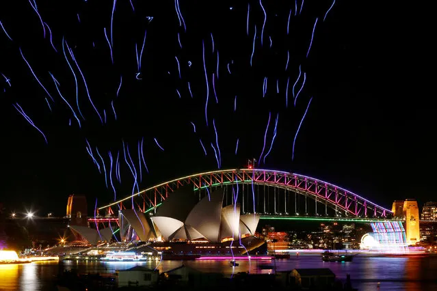 An aerial performance featuring 100 illuminated drones lift off from a barge on Sydney Harbour in front the Sydney Harbour Bridge and Opera House during the Vivid Sydney light festival in Sydney, Australia, June 9, 2016. (Photo by Jason Reed/Reuters)