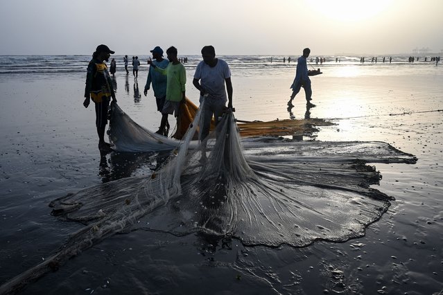 Fishermen prepare their nets before catching fish on the Clifton beach in Karachi on September 10, 2024. (Photo by Rizwan Tabassum/AFP Photo)