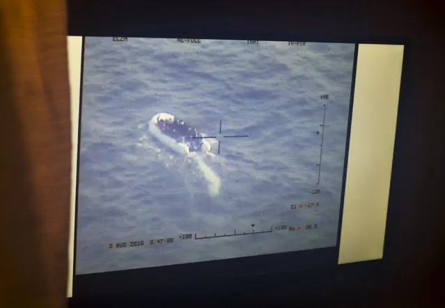 Live video footage transmitted from a Schiebel Camcopter S-100 drone showing a rubber dinghy packed with 118 migrants is seen on a monitor on board the Migrant Offshore Aid Station (MOAS) ship MV Phoenix, some 20 miles (32 kilometres) off the coast of Libya, August 3, 2015. (Photo by Darrin Zammit Lupi/Reuters)