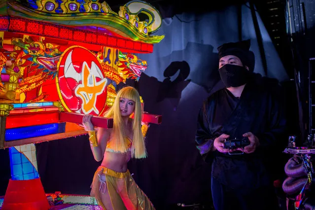 A stage hand dressed as a ninja controls a vehicle by remote control during a show at The Robot Restaurant on June 29, 2014 in Tokyo, Japan. The now famous Robot Restaurant opened two years ago in Kabukicho area of Shinjuku at an estimated cost of 10 million U.S. dollars. (Photo by Chris McGrath/Getty Images)
