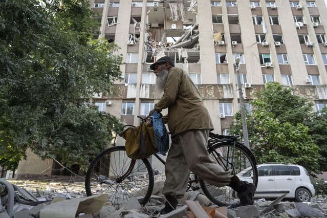 A man walks in front of a building which was heavily damaged by a Russian airstrike in Kherson, Ukraine, Thursday, June 15, 2023. (Photo by Evgeniy Maloletka/AP Photo)