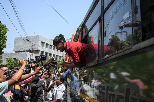 A Bharatiya Janata Party (BJP) activist (R) speaks to members of the press from a police vehicle after being detained during a protest against West Bengal's state government over alleged irregularities in the School Service Commission (SSC) recruitment process, in Kolkata on May 20, 2022. (Photo by Dibyangshu Sarkar/AFP Photo)