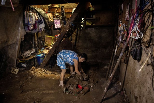 Elenita P. Cervantes, 60, tries to recover her belongings covered in mud after her house was flooded due to Tropical Storm Yagi, locally known as Enteng, in Pilila, Rizal province, Philippines on September 4, 2024. (Photo by Eloisa Lopez/Reuters)