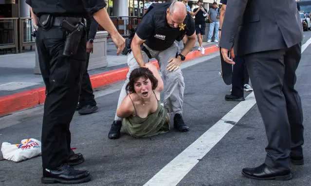 A Secret Service police officer wrestles a protester to the ground after she ran towards a motorcade on its way to the LA Convention Center where North and South American leaders are gathered for the ninth Summit of the Americas in Los Angeles, June 8, 2022. (Photo by Apu Gomes/AFP Photo)