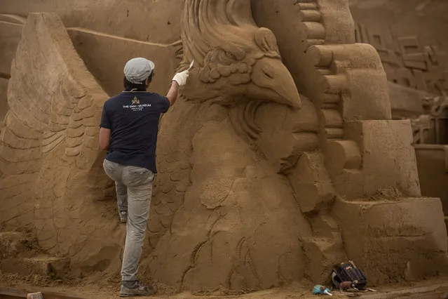 Sand sculptor Katsuhiko Chaen works on a large sand sculpture at the site of Yokohama Sand Art Exhibition – Culture City of East Asia 2014 on July 16, 2014 in Yokohama, Japan. Producer and sand sculptor Katsuhiko Chaen invited artists from around the world including South Korea and China, to recreate the World Heritage and historical buildings in China, Japan and South Korea. The exhibition will be open from July 19 to November 3, 2014. (Photo by Chris McGrath/Getty Images)
